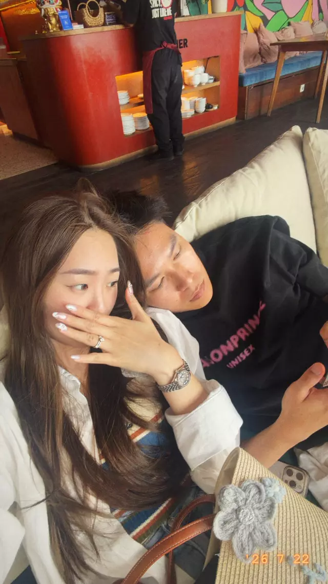 A ring on her finger as she covers a smile