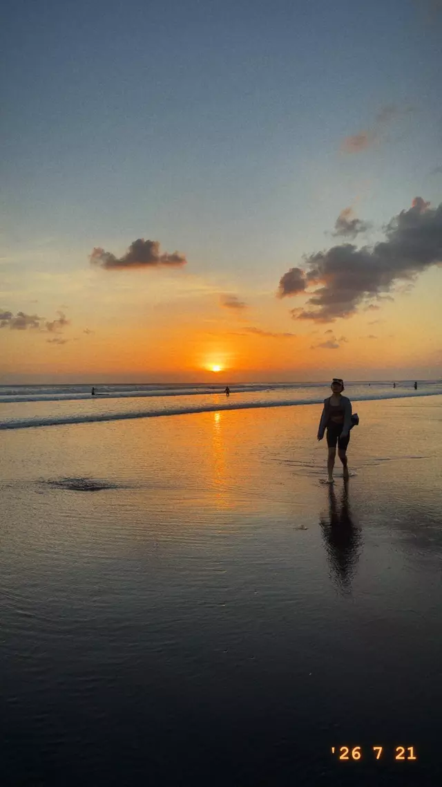 A friend walking along the beach at sunset