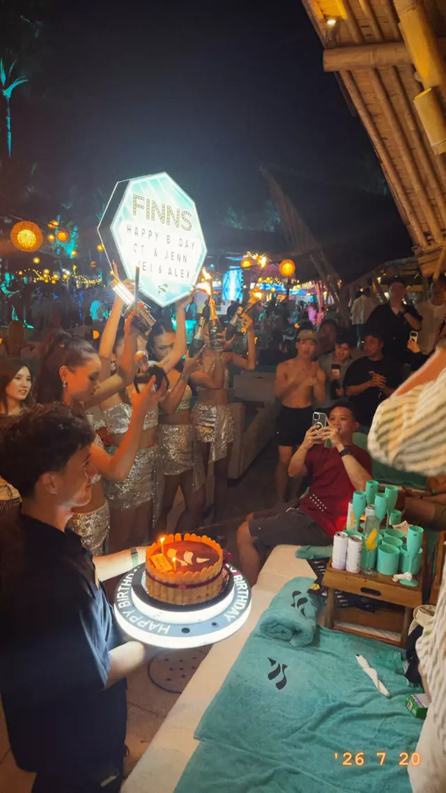 A cake with a sparkler carried through the crowd