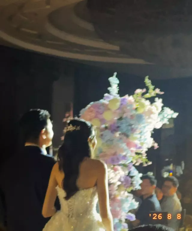 The couple beside a tower of flowers