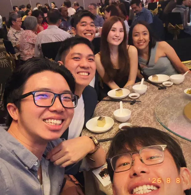 A table of friends squeezing into a selfie