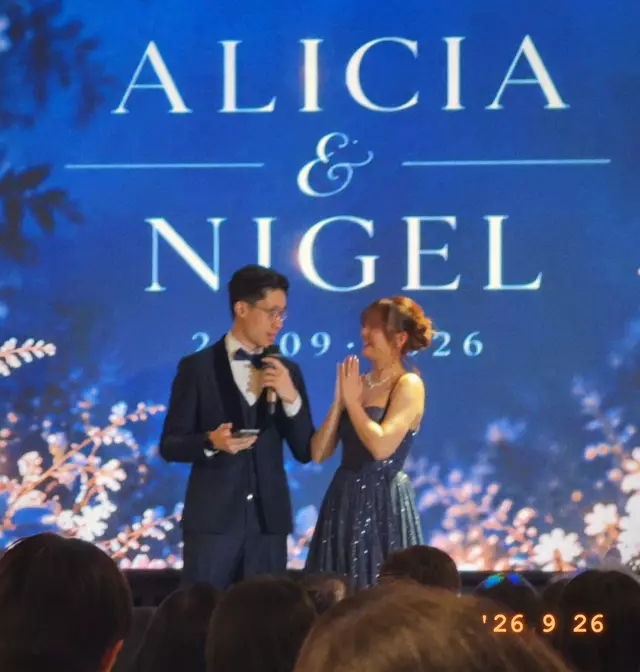 The couple on stage in front of the big screen