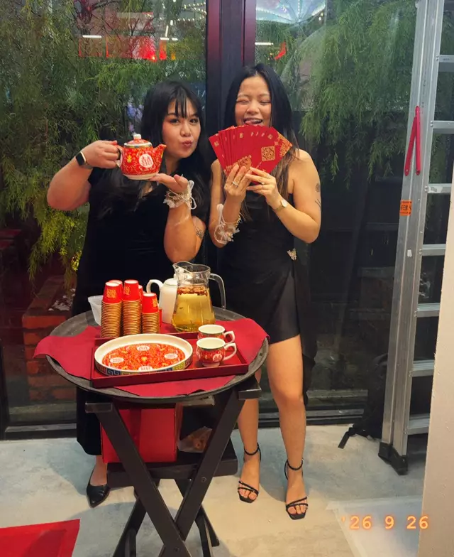 Two guests at the tea ceremony, holding a red packet